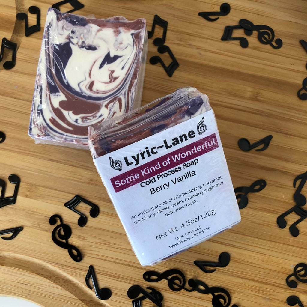 Two 4oz bars of Some Kind of Wonderful cold processed soap on a wood guitar shape with scattered music notes. Scented with berry vanilla. Designed with a maroon, purple and white swirl pattern. Made by Lyric-Lane