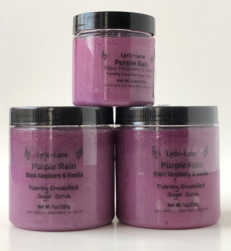 Three jars of Purple Rain-Black Raspberry & Vanilla scented whipped emulsified sugar scrub stacked in a pyramid on a white background. Two 7 oz PET plastic jars side by side on the bottom and one 3.5 oz jar stacked on top. Made by Lyric-Lane.