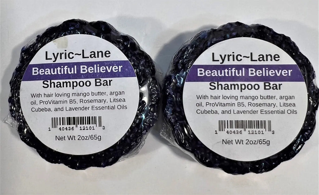 Two 2oz round bars of Beautiful Believer Shampoo Bars laying side by side. Purple bars scented with rosemary, litsea cubeba, and lavender essential oils on a white background. Made by Lyric-Lane