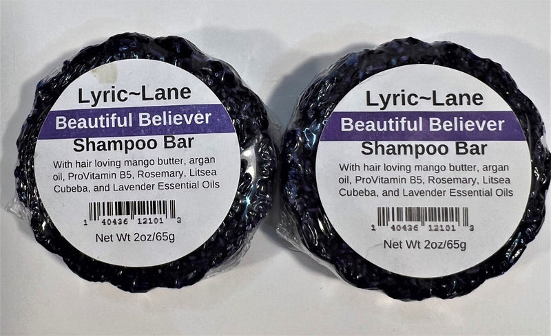 Two 2oz round bars of Beautiful Believer Shampoo Bars laying side by side. Purple bars scented with rosemary, litsea cubeba, and lavender essential oils on a white background. Made by Lyric-Lane
