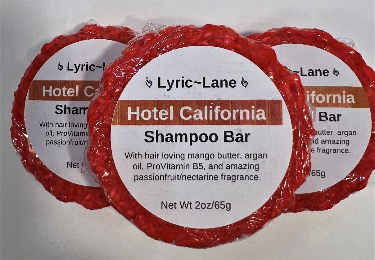 Three 2oz round bars of Hotel California Shampoo Bars. Crimson bars scented with passionfruit and nectarine stacked in a pyramid on a white background. Made by Lyric-Lane
