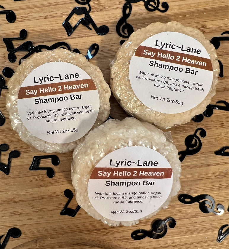 Three 2oz round bars of Say Hello 2 Heaven Shampoo Bars. Cream colored bars scented with vanilla fragrance on a wood guitar shape with scattered music notes. Made by Lyric-Lane